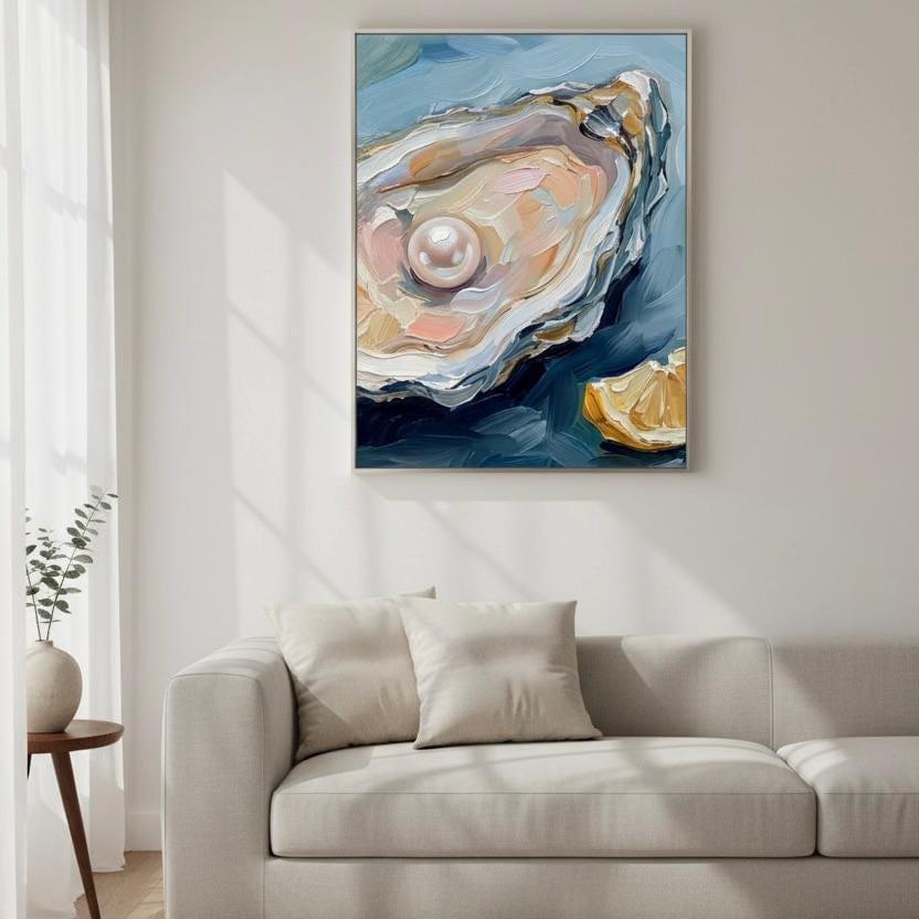 a large painting of an oyster shell with a pearl hanging on the wall above a beige sofa with two pillows.