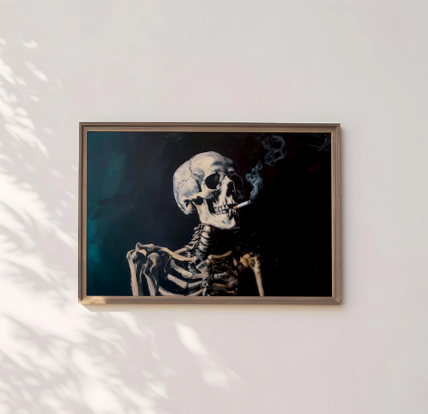 A framed painting of a skeleton smoking a cigarette is hanging on a white wall.
