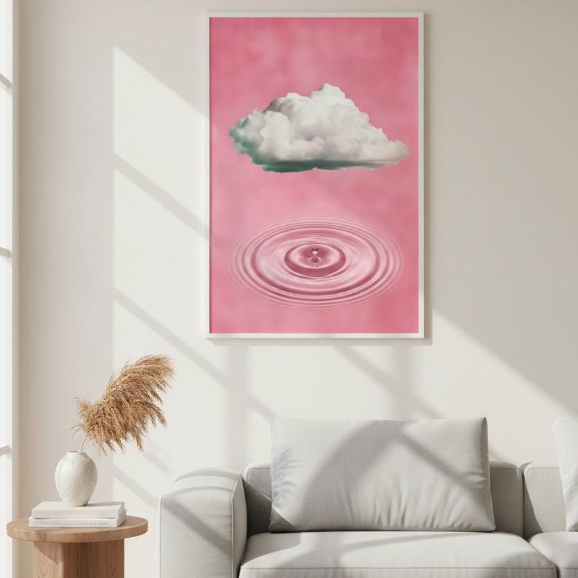 a large pink poster hanging on a white wall, depicting a cloud and a water droplet. The poster is framed and placed above a gray couch in a living room setting.