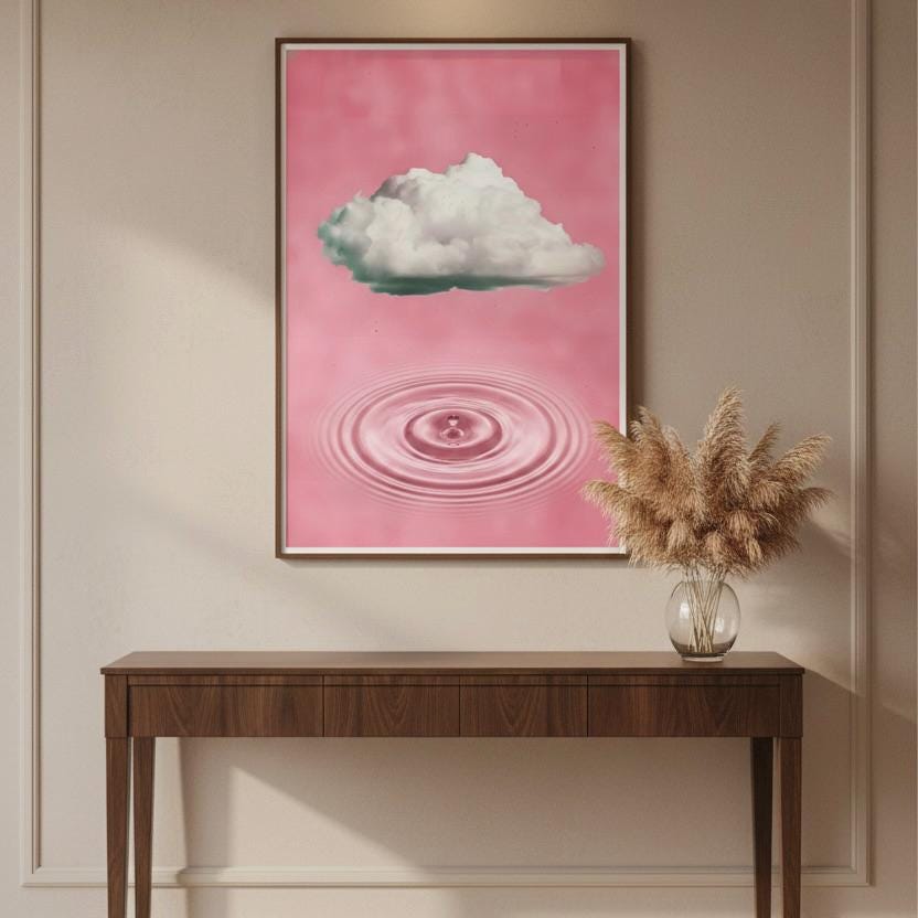 a framed poster of a cloud and a water droplet on a pink background, hanging on a wall above a wooden console table.