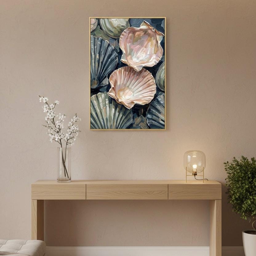 a wooden console table with a vase of white flowers and a lamp on it, set against a wall with a framed picture of seashells hanging above it.