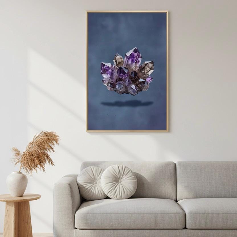 a large framed picture of a cluster of purple crystals hanging on a wall above a gray couch with two round pillows.